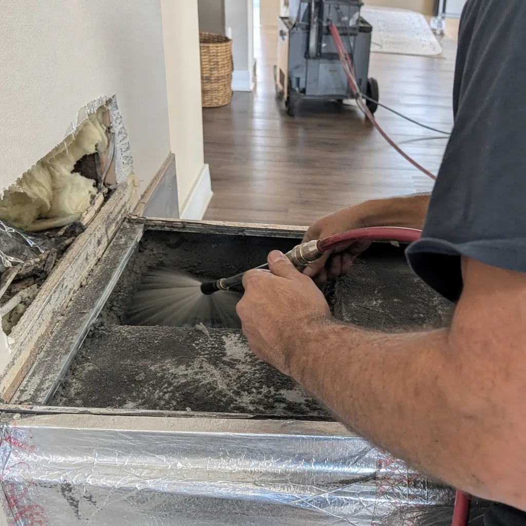 Technician performing professional residential air duct cleaning service with specialized tools